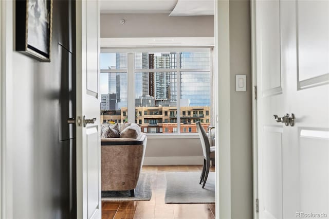 interior space with a view of city, baseboards, and wood finished floors