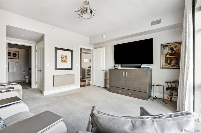 living room featuring light carpet, visible vents, and baseboards