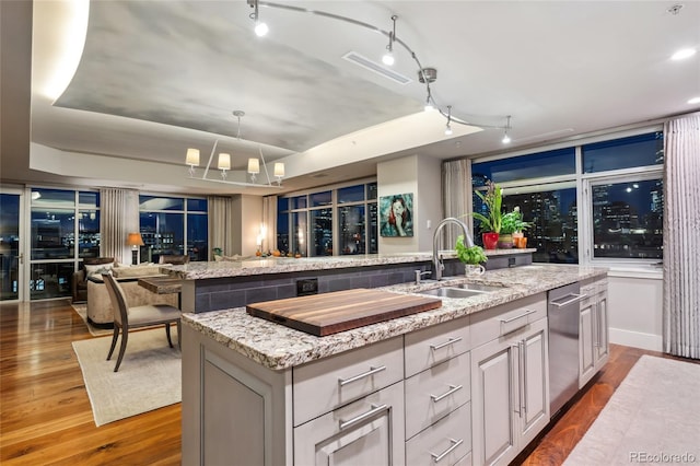 1411 Wynkoop St Unit 806, Denver, CO 80202 - kitchen featuring a sink, open floor plan, track lighting, a center island with sink, and a raised ceiling