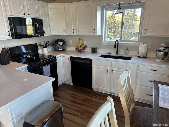 kitchen with black appliances, decorative light fixtures, dark wood-type flooring, white cabinetry, and sink