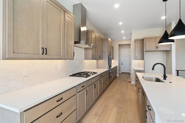 1585 Winter Glow Dr, Windsor, CO 80550 - kitchen featuring tasteful backsplash, wall chimney exhaust hood, light wood finished floors, stainless steel gas stovetop, and a sink