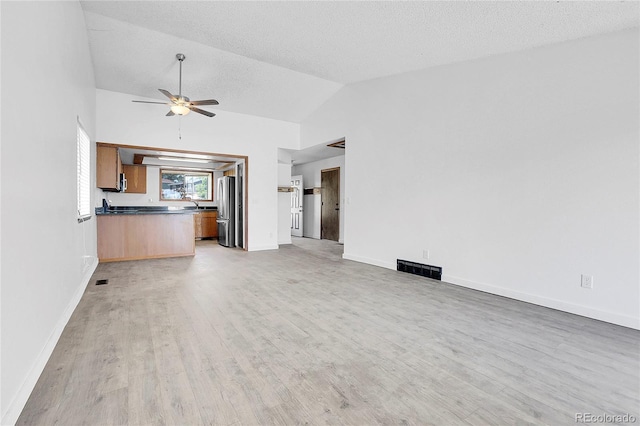 7610 S Garland St, Littleton, CO 80128 - unfurnished living room featuring light wood-style flooring, ceiling fan, and lofted ceiling