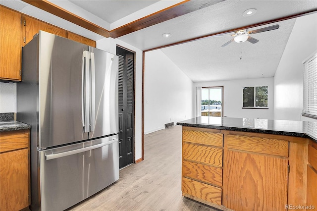 7610 S Garland St, Littleton, CO 80128 - kitchen with freestanding refrigerator, ceiling fan, light wood-style floors, brown cabinetry, and lofted ceiling