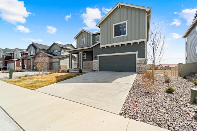 view of front of home with a residential view, driveway, board and batten siding, a garage, and fence