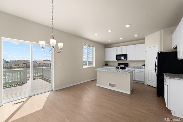 kitchen with white cabinetry, visible vents, black appliances, a chandelier, and wood finished floors