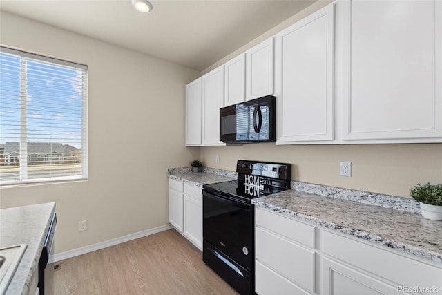 kitchen with baseboards, white cabinetry, black appliances, light stone countertops, and light wood-style flooring