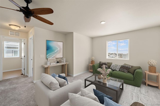carpeted living room with visible vents, baseboards, and a healthy amount of sunlight