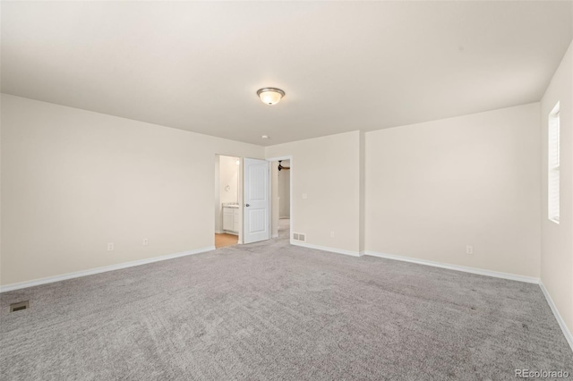 empty room with visible vents, baseboards, and light carpet