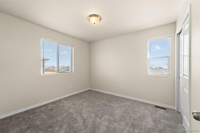 unfurnished bedroom featuring visible vents, baseboards, and carpet