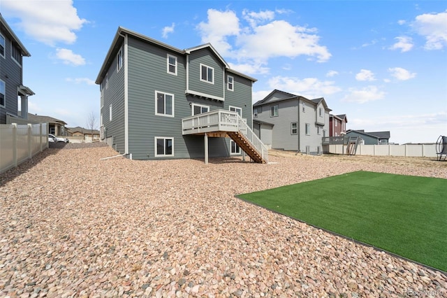 rear view of house featuring a yard, fence, stairway, and a deck