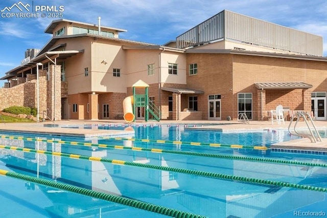 pool featuring a patio area and a water slide
