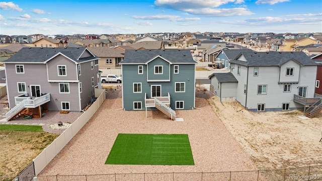 back of property featuring a residential view, a fenced backyard, and stairs