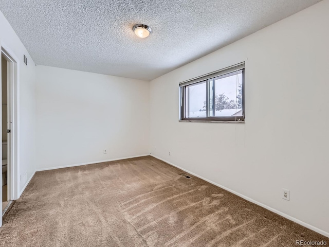 unfurnished room with a textured ceiling and carpet