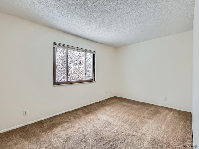 unfurnished room featuring a textured ceiling and carpet floors