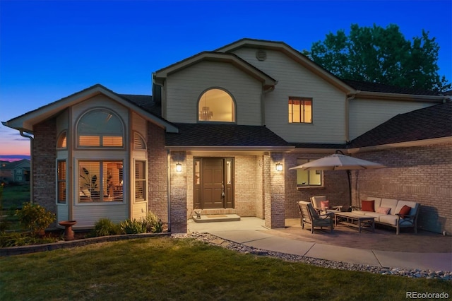 7289 Stroh Rd, Parker, CO 80134 - view of front of home with an outdoor living space, brick siding, a patio area, a front yard, and a shingled roof