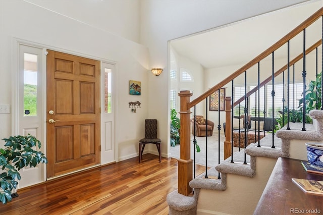 7289 Stroh Rd, Parker, CO 80134 - foyer entrance featuring wood finished floors, stairway, baseboards, and a high ceiling