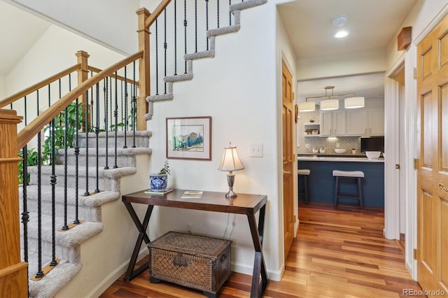 7289 Stroh Rd, Parker, CO 80134 - corridor with light wood-style flooring, stairs, baseboards, and recessed lighting