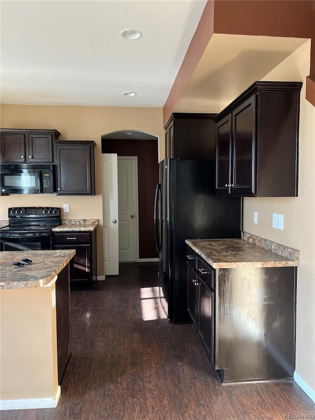 kitchen with dark brown cabinets, dark hardwood / wood-style floors, black appliances, and light stone countertops