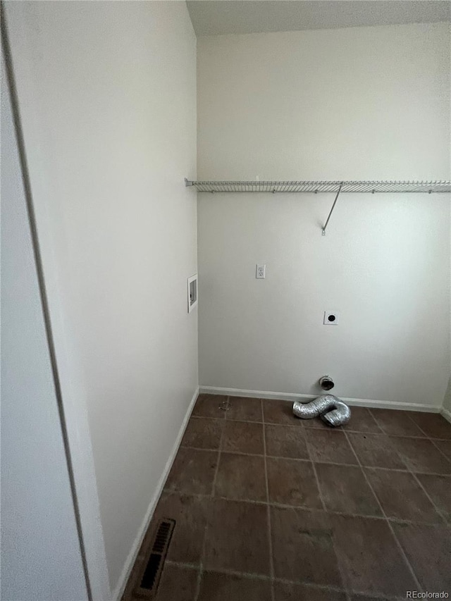 laundry room with dark tile floors, electric dryer hookup, and hookup for a washing machine