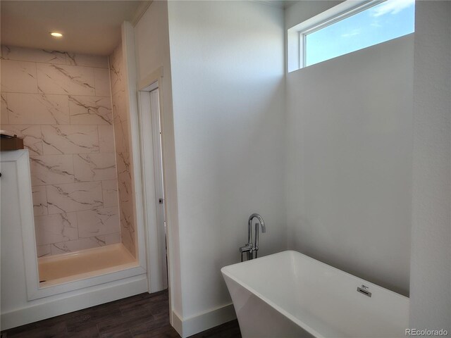 bathroom featuring hardwood / wood-style flooring and plus walk in shower