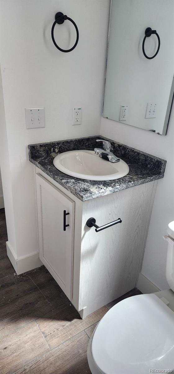 bathroom featuring vanity, toilet, and hardwood / wood-style flooring