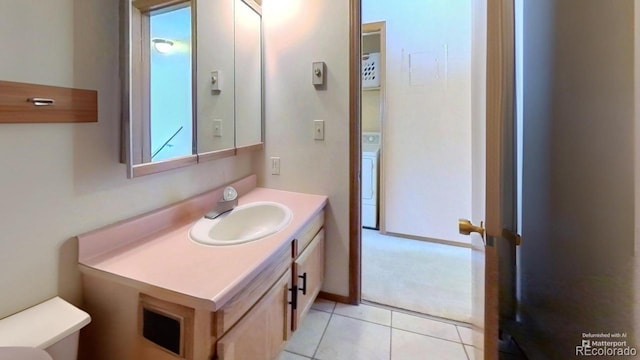 bathroom with washer / clothes dryer, vanity, tile patterned floors, and toilet