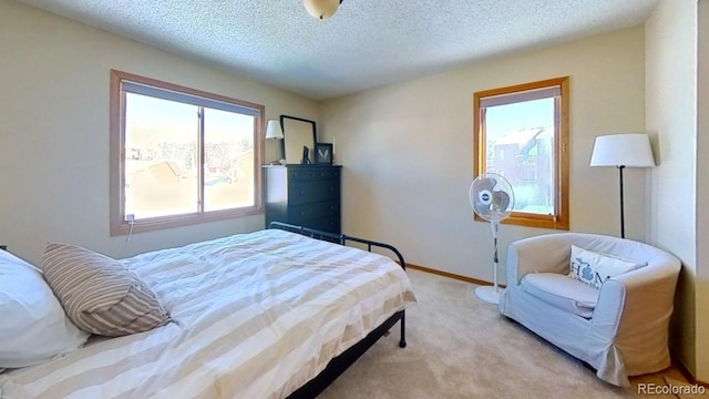 bedroom with light colored carpet and a textured ceiling