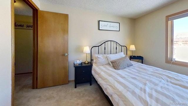 bedroom featuring light colored carpet and a textured ceiling