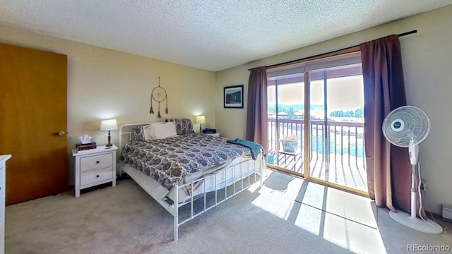 carpeted bedroom with access to outside and a textured ceiling