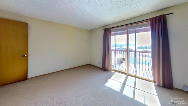 carpeted empty room featuring a textured ceiling