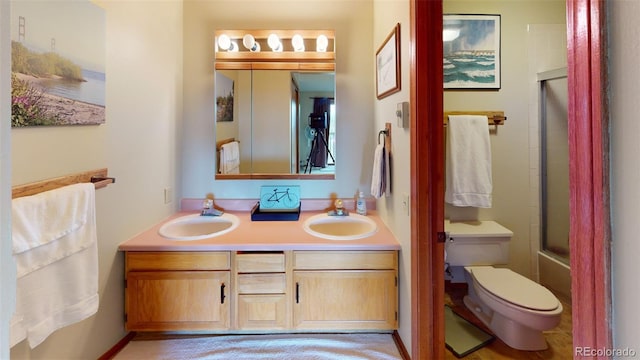 full bathroom featuring enclosed tub / shower combo, vanity, and toilet