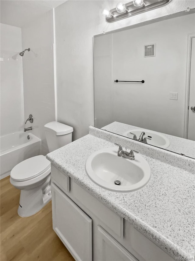 full bathroom featuring vanity, wood-type flooring, bathtub / shower combination, and toilet