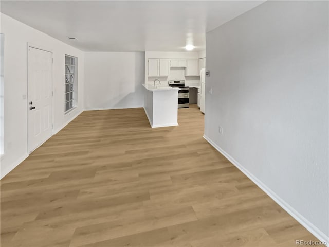 unfurnished living room featuring sink and light wood-type flooring