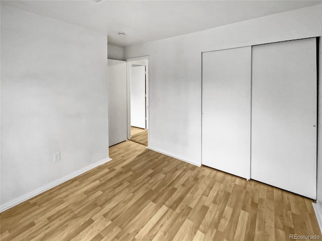 unfurnished bedroom featuring light hardwood / wood-style floors and a closet