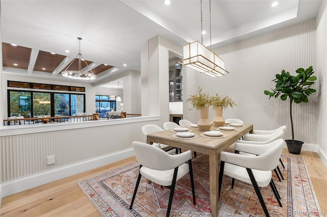 dining space with an inviting chandelier and light hardwood / wood-style flooring