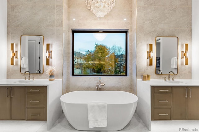 bathroom featuring a tub, vanity, a chandelier, and tile walls