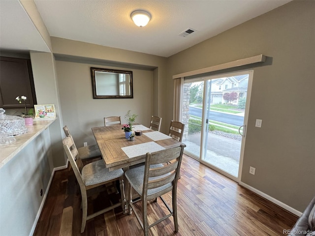 dining room featuring dark hardwood / wood-style floors and a textured ceiling