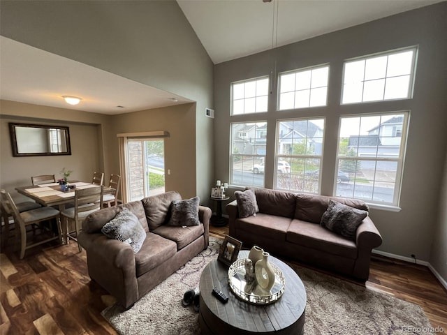 living room with dark hardwood / wood-style flooring and high vaulted ceiling