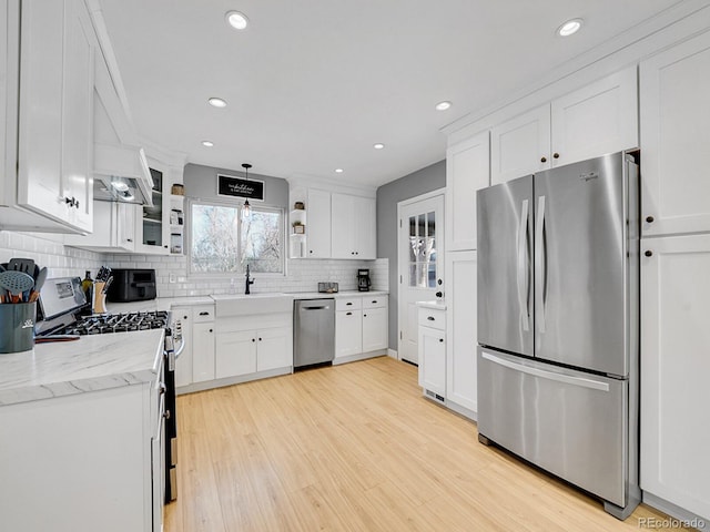 kitchen featuring stainless steel appliances, pendant lighting, and white cabinets