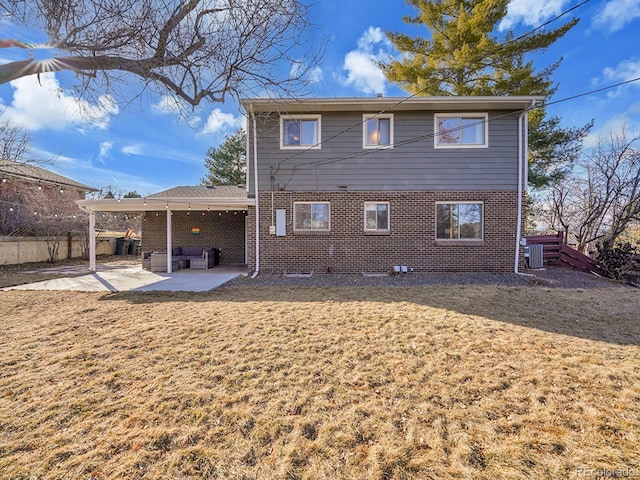 rear view of property featuring a lawn and a patio area