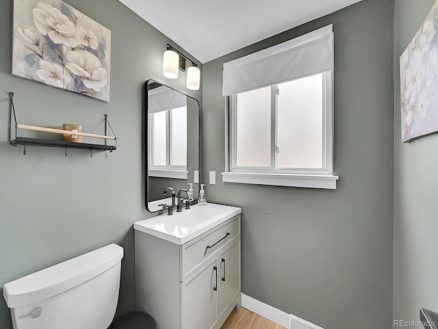 bathroom with vanity, hardwood / wood-style floors, and toilet