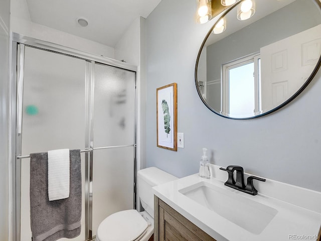 bathroom featuring vanity, toilet, and an enclosed shower