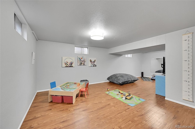 rec room with wood-type flooring and a textured ceiling