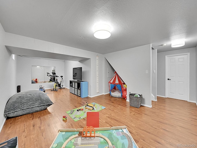 game room featuring wood-type flooring and a textured ceiling