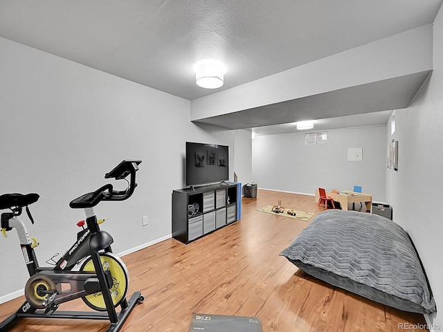 exercise area featuring hardwood / wood-style floors and a textured ceiling