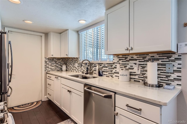 kitchen with dark hardwood / wood-style flooring, sink, appliances with stainless steel finishes, white cabinets, and a textured ceiling