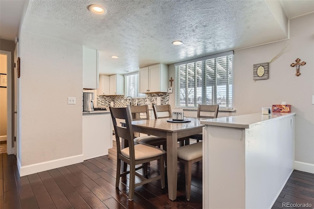 dining space with a textured ceiling and dark hardwood / wood-style floors