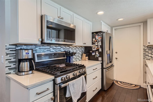 kitchen with decorative backsplash, white cabinetry, stainless steel appliances, and a textured ceiling