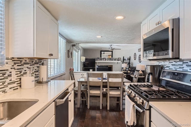 kitchen with backsplash, white cabinetry, and appliances with stainless steel finishes