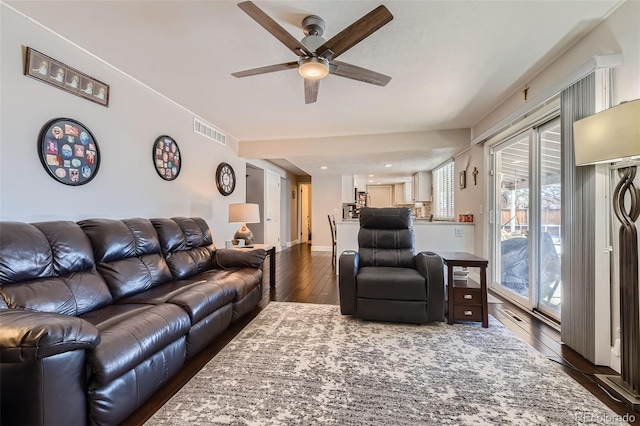 living room featuring dark wood-type flooring and ceiling fan